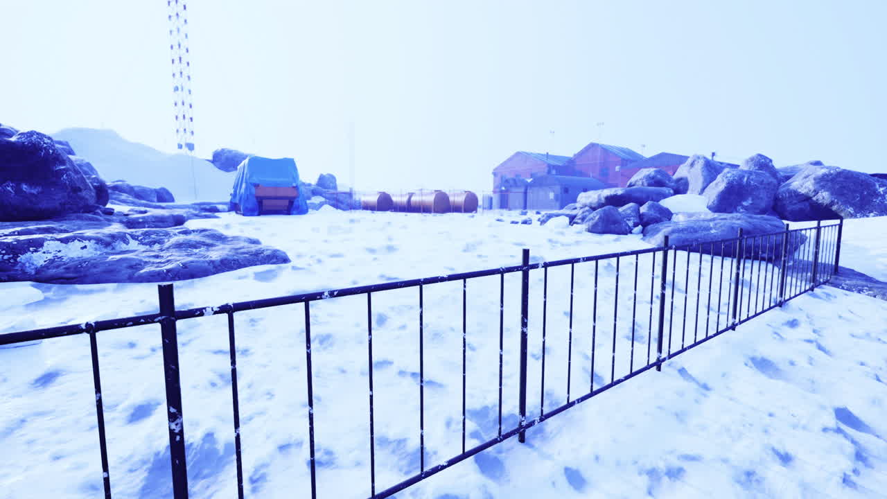 Snowy winter landscape with distant buildings in a remote area