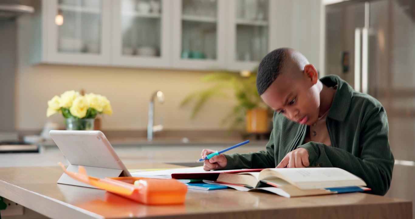 Young Boy Studying with Books and Tablet at Home