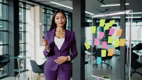 professional businesswoman in purple suit in a modern office with sticky notes