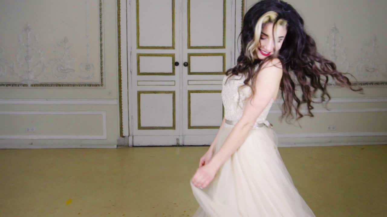 una joven morena con labios rojos sopla confeti dorado