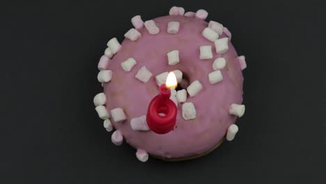 donut dulce girando sobre un fondo negro. vista superior. donut sabroso y fresco