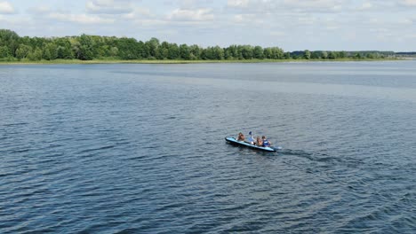 aerial drone tracking shot of a dinghy boat sailing in the sea surrounded by islands