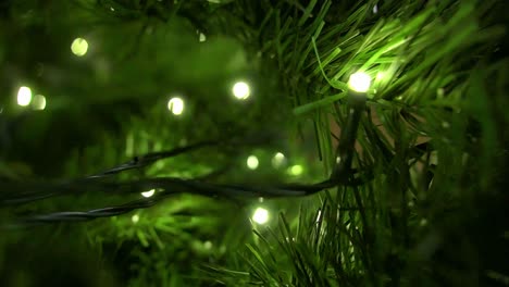 close up view inside a christmas tree lights glowing, indoor livingroom during holidays