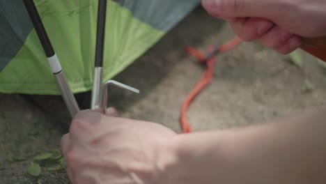 [slow motion] [close up] shot of someone pounding a tent peg into dirt