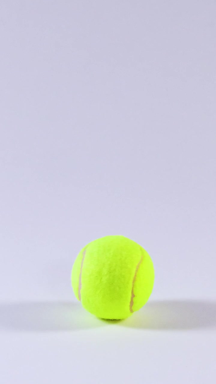 Tennis ball rolling across a smooth surface
