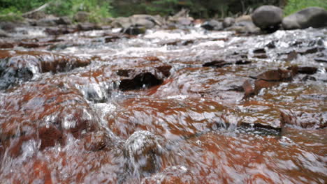 Fluss-In-Zeitlupe,-Der-Aus-Nächster-Nähe-über-Rote-Felsen-Fließt