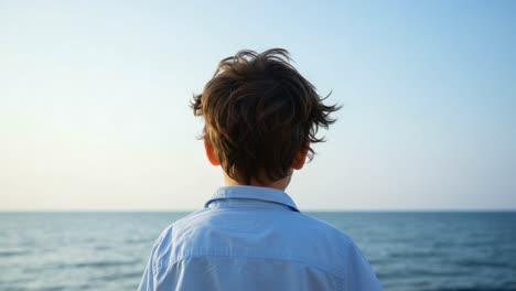 a young child reflects on life by the ocean, capturing the essence of innocence and wonder as he gazes at the tranquil waters of the sea