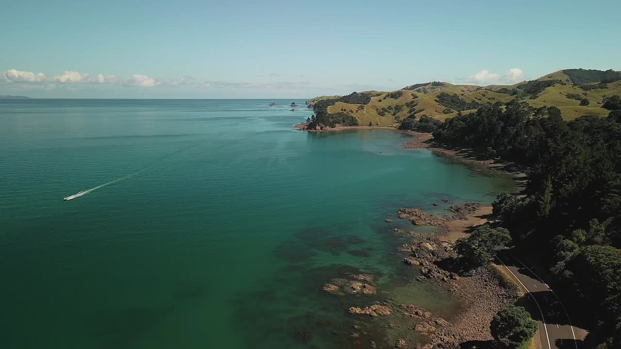 vuelo de drones sobre la carretera costera que rodea las montañas de nueva zelanda en la península de coromandel
