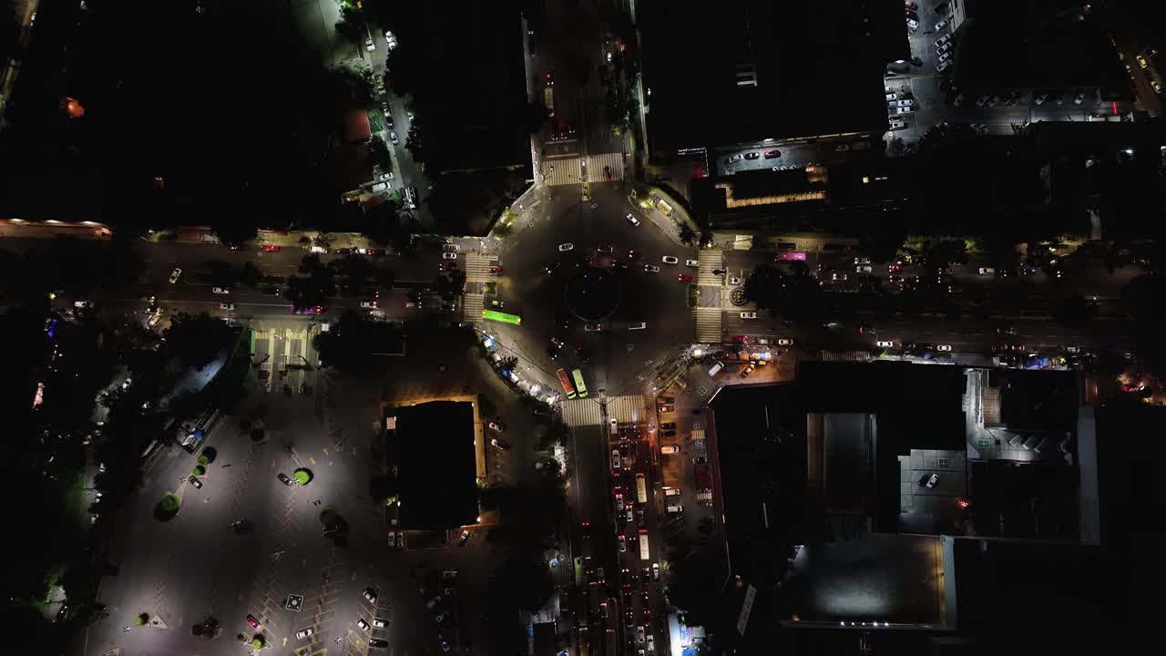Drone's bird's-eye view of a roundabout with constant car traffic