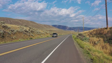 Cruisen-Durch-Die-Landschaft:-Schwarzer-Pickup-Auf-Dem-Highway-1,-Vorbei-An-Landwirtschaftlich-Genutzten-Bewässerungsflächen-In-Der-Nähe-Von-Cache-Creek,-Britisch-Kolumbien,-Kanada