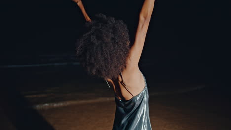 chill girl move hands on beach party back view. slim woman body in silver dress