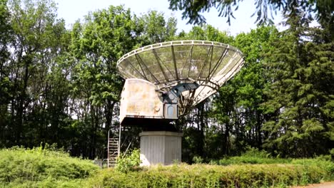 abandoned satellite dish in a forest