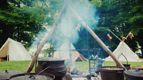 숲 음식에 있는 아메리카 원주민 캠프가 전경 전통 wigwam 텐트에서 준비되고 있습니다.
