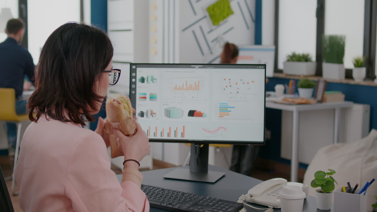 mujer de negocios que trabaja en la oficina de una empresa de inicio que tiene comida para llevar a la hora del almuerzo