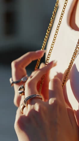 close-up of hands adorned with rings and gold chain