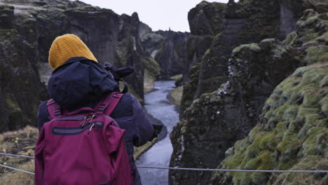 tourist taking picture in fjadrargljufur canyon in iceland