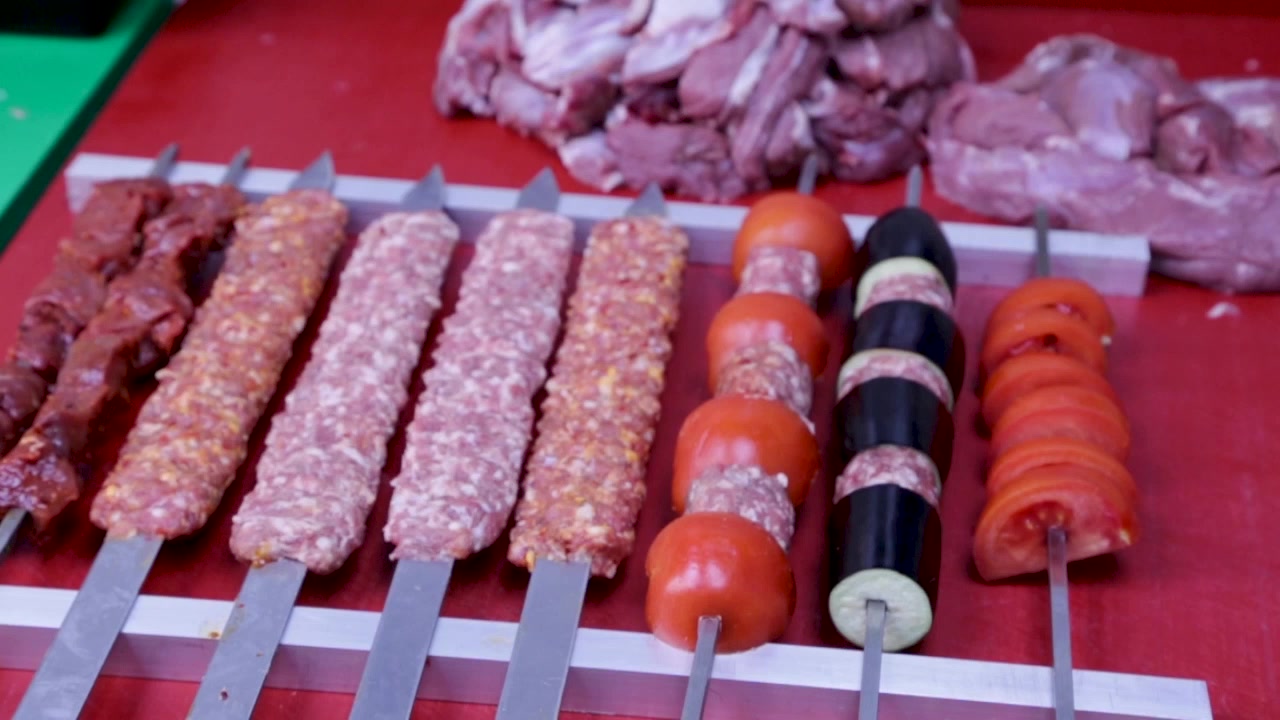 Un set di spiedini di carne preparati da mettere su una griglia a carbone