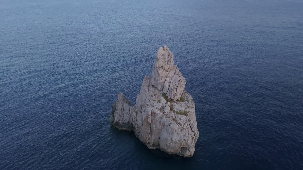 Ibiza'da Benirras kayalığının boş denizin ortasındaki drone vinç çekimi