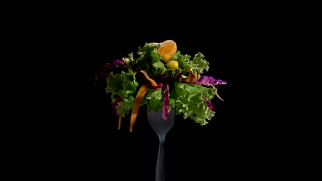 vegetables salad food on fork on black background.