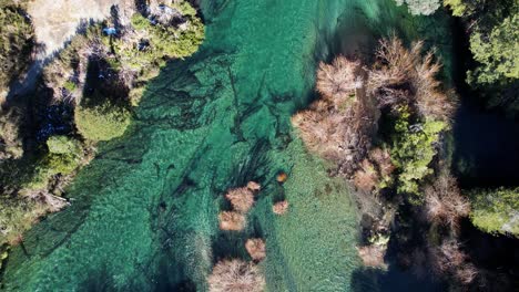 crystal clear river water in argentina, aerial top down view