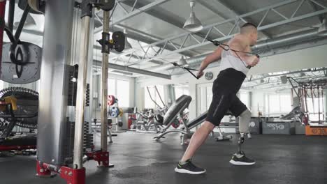 Hombre-Discapacitado-Atlético-Fuerte-Con-Pierna-Protésica-Haciendo-Ejercicios-Durante-El-Entrenamiento-De-Gimnasio