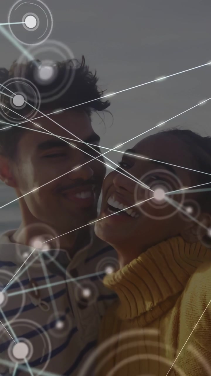 Vertical video: Couple kissing by sea while camera activating HUD over faces for tech demo