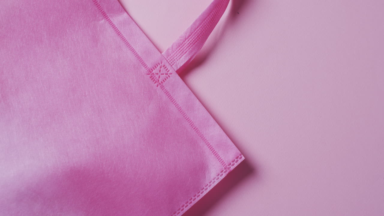 video de una bolsa de lienzo rosa con espacio de copia en un fondo rosa