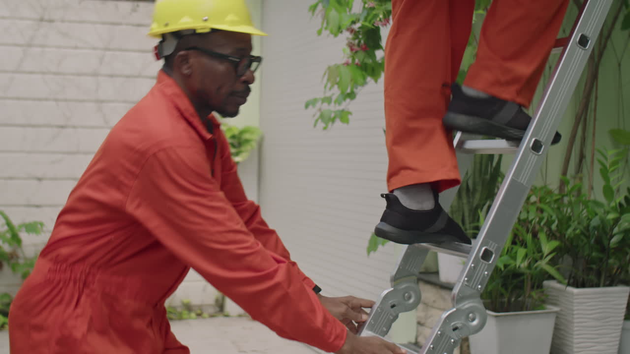 Two Workers Installing Solar Panel on Rooftop