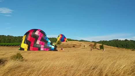 hot air balloon is being deflated after landing on a field