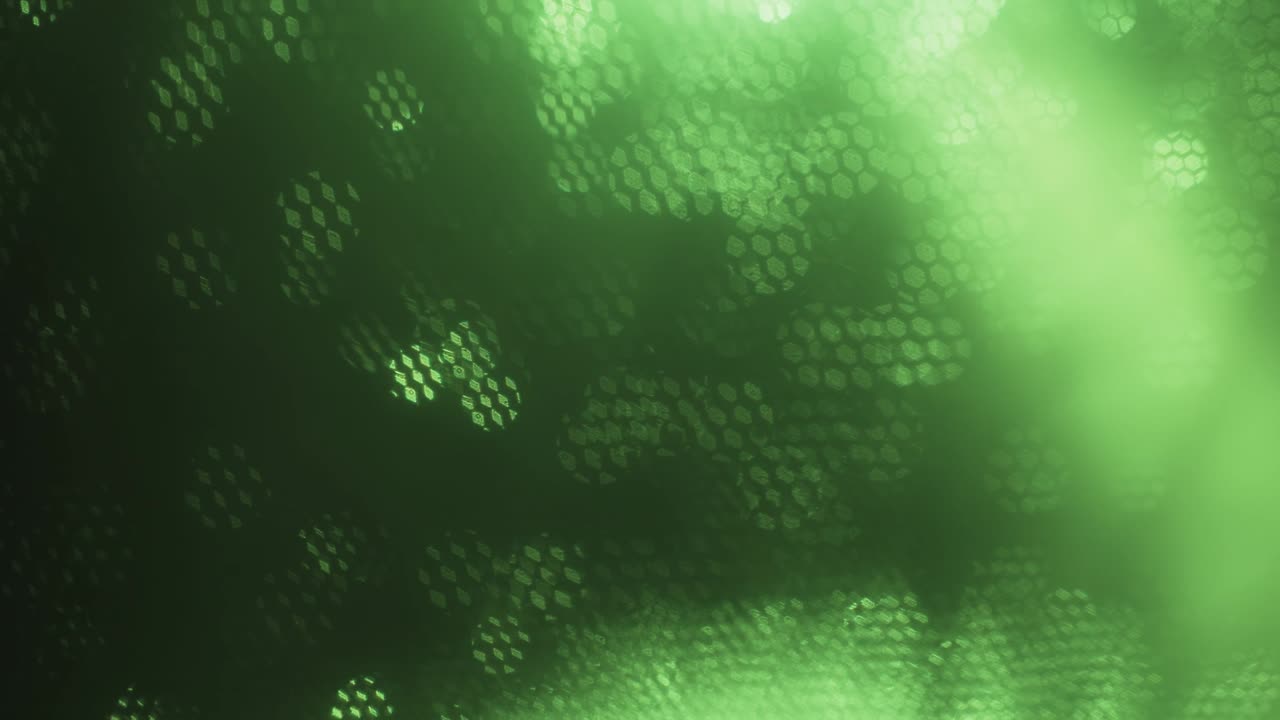 Sfondo verde astratto ottico sfocato. Bokeh ottico sovrapposto da nidi d'ape in movimento