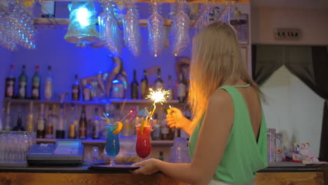 waitress in the bar lighting bengal fires in cocktail glasses