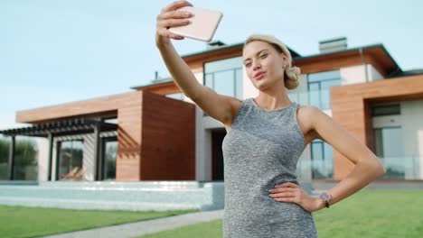 hermosa mujer tomando una foto de selfie afuera de un apartamento de lujo