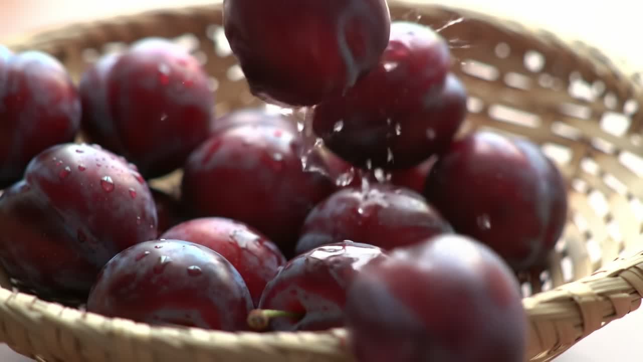 Fresh Plums in a Woven Basket, Capturing Their Vibrant Colors and Juicy Texture