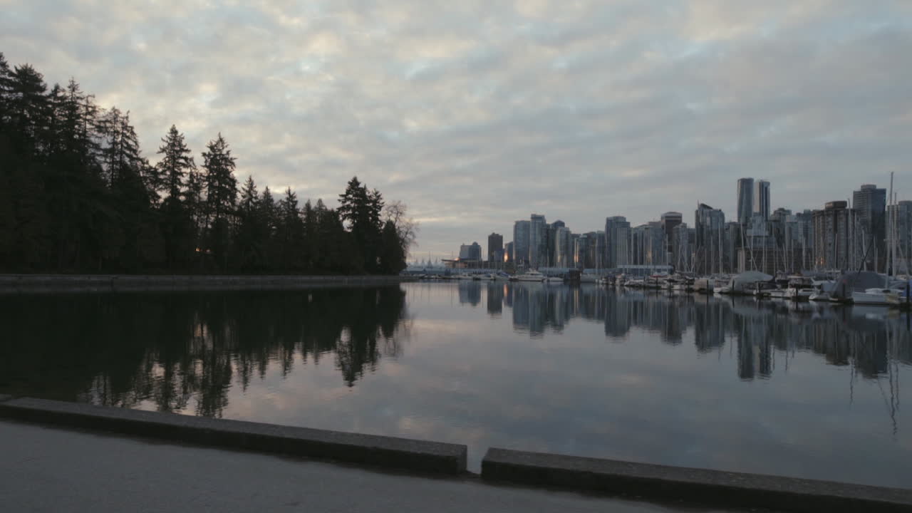Ampia carrellata di un sentiero di Stanley Park e barche nel porto turistico al mattino, West End di Vancouver, al rallentatore