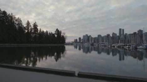 wide camera roll shot of a stanley park trail and boats in morning marina, vancouver west end, slowmotion