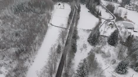 bird's eye view of a moving car in a winter rural landscape covered in snow. drone view