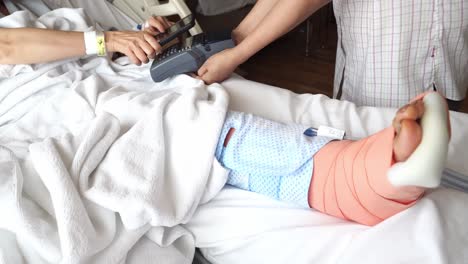 after surgery, a patient pays the medical bill using contactless payment with mobile phone