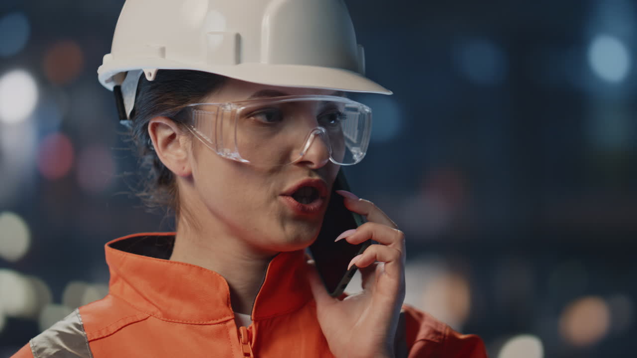 retrato empleado de fabricación llamando al teléfono en la fábrica. mujer ingeniera hablando