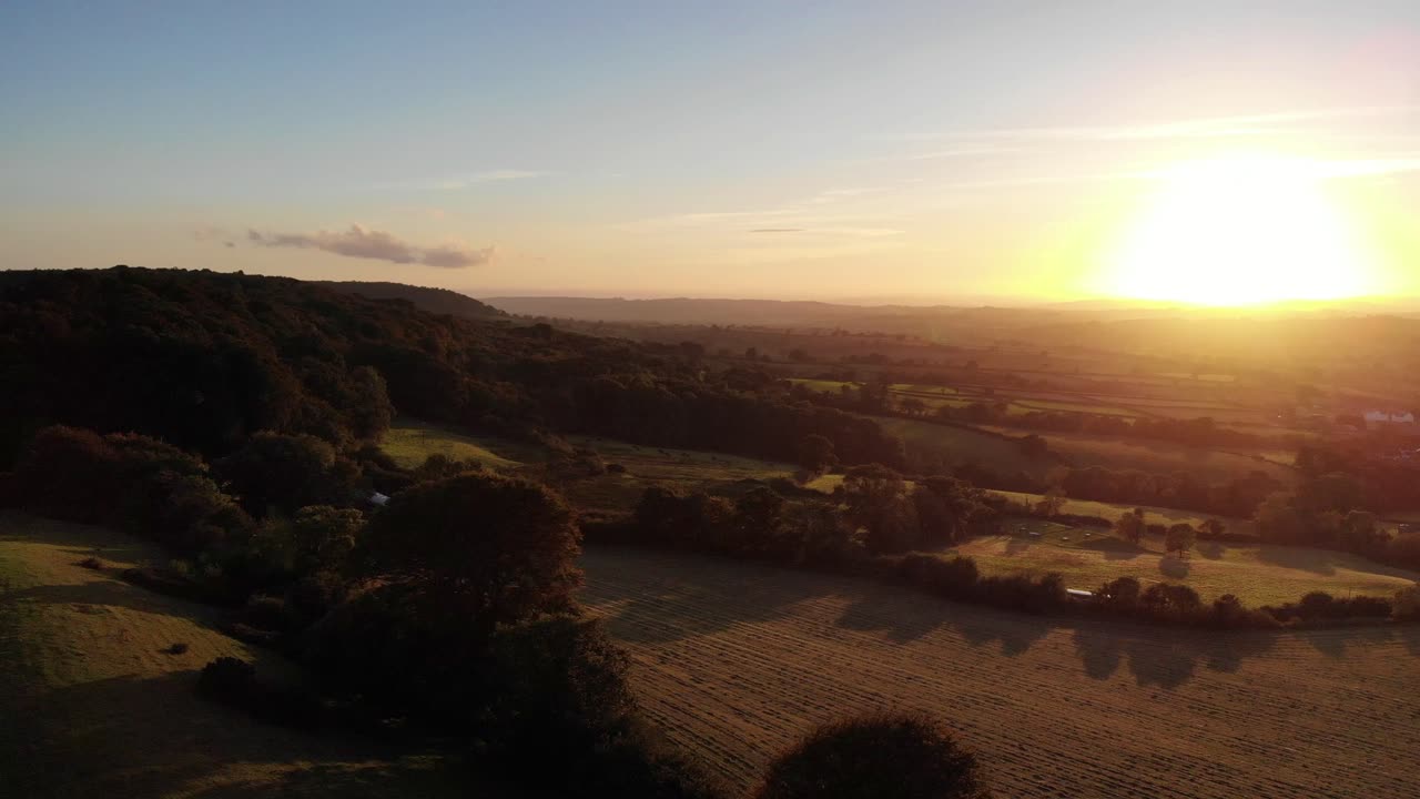 Aerial rising shot of a beautiful golden sunset over East Devon in England