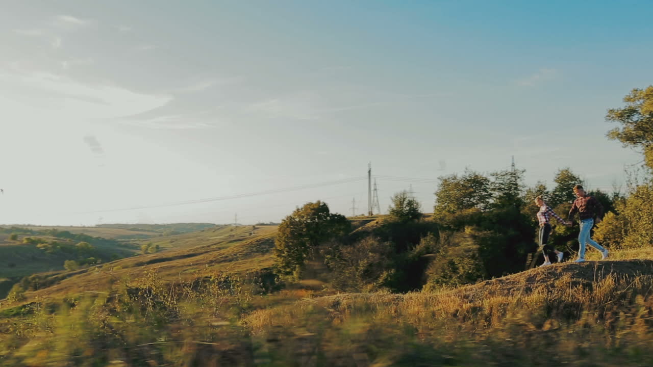 Couple Running On A Meadow. Man and woman holding hands while walking in nature