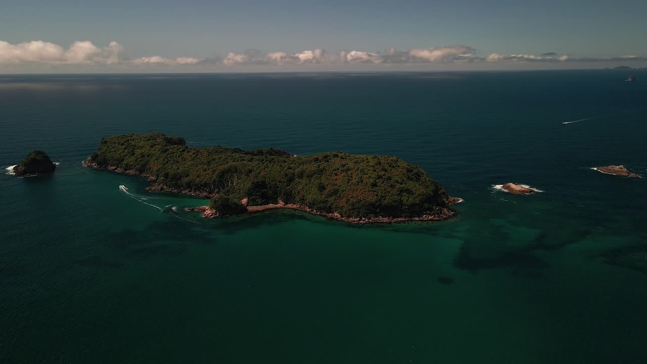 Barco navegando ao redor de ilha tropical deserta