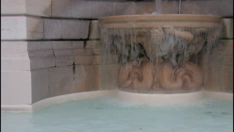 a stone fountain with a sculpture and flowing water