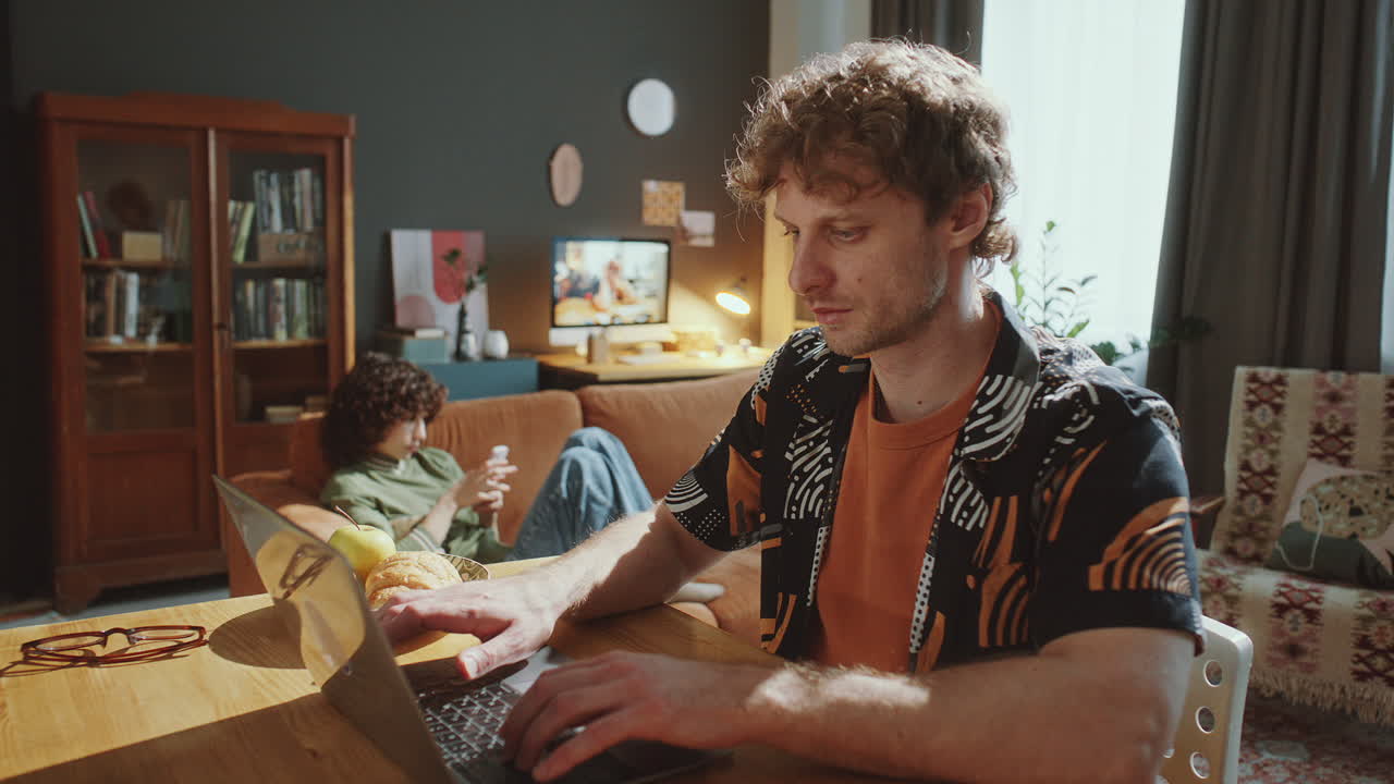 Young Focused Man Working on Laptop during Day at Home
