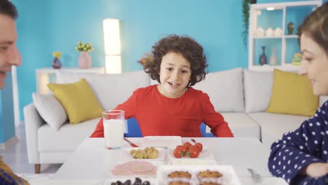 Cute-boy-is-happy-to-see-happy-family-breakfast-and-loves-his-parents.