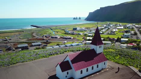 aerial establishing shot of the town of vik in southern iceland its iconic church 2