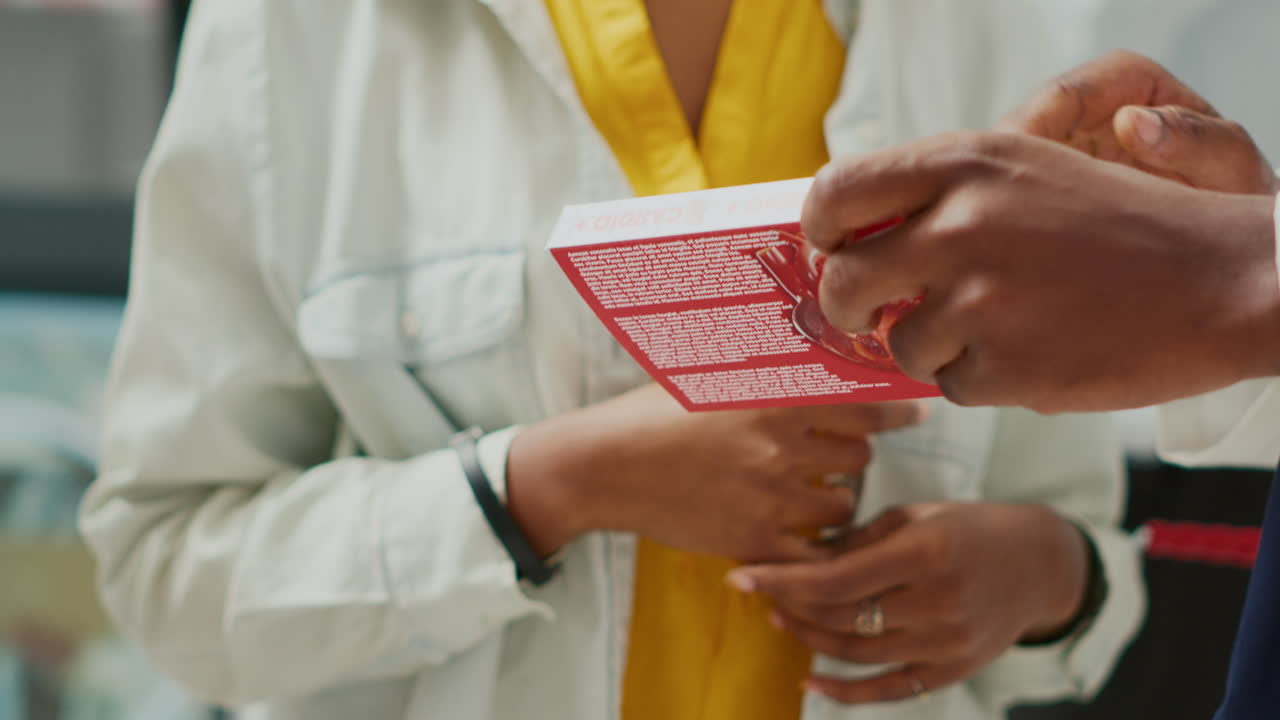Close-up of people holding a box of medication in a pharmacy