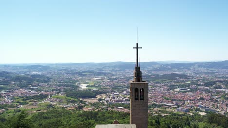 Luftaufnahme-Des-Kirchturms-Von-Monte-Da-Penha-Mit-Kreuz-Und-Blick-Auf-Guimarães,-Portugal