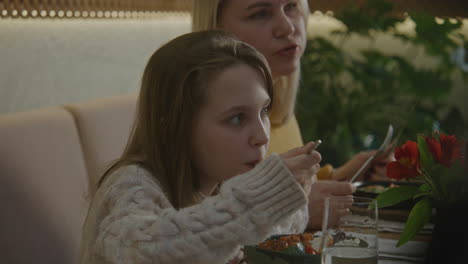 mother and daughter eating in a restaurant
