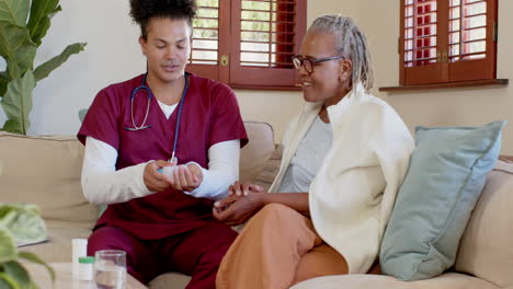 caregiver in scrubs assisting senior woman at home, sharing warm conversation