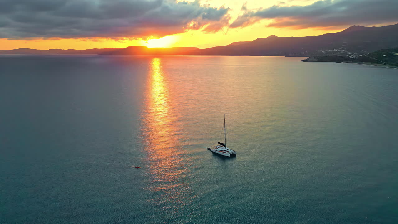 A sailboat in Sitia's port is on the Sea of Crete, Greece on the Aegean Sea at sunset - aerial parallax